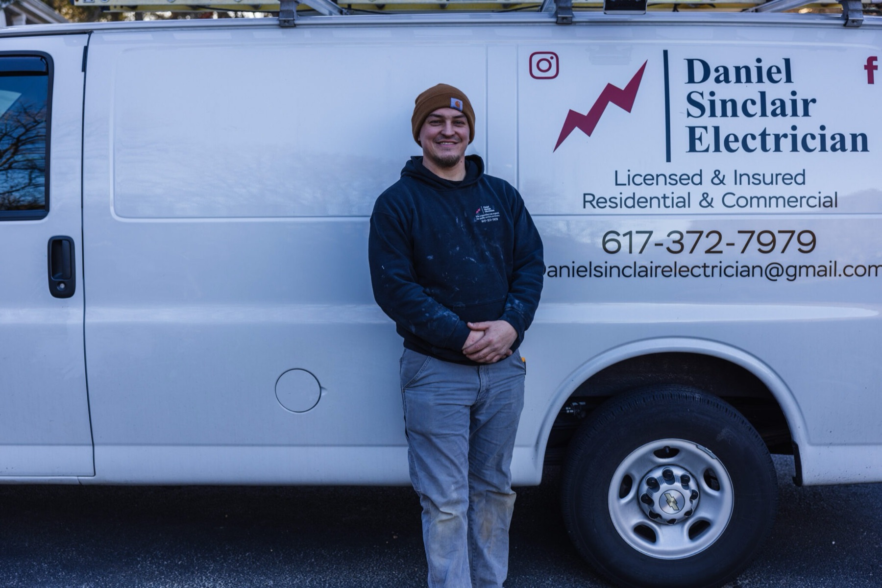Daniel Sinclair standing beside his Daniel Sinclair Electrician work van