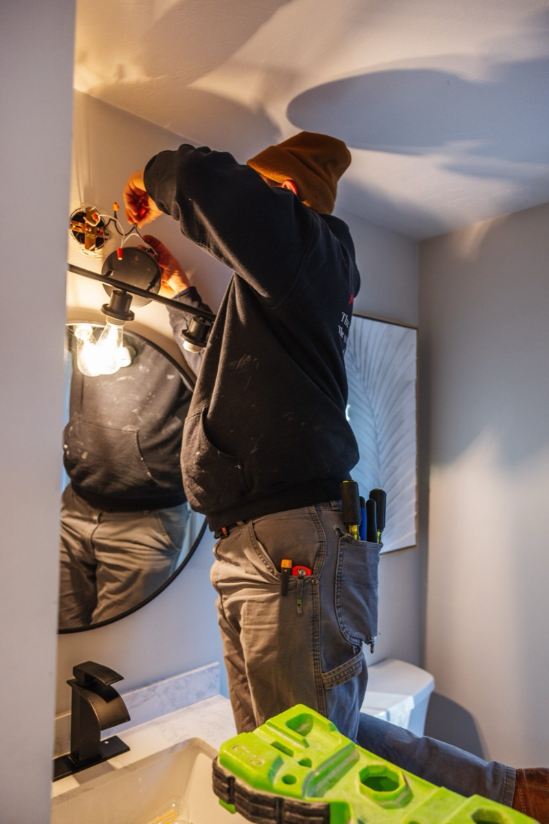 Daniel Sinclair installing a light fixture